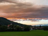 Langgezogener Wolkenstreifen am Abendhimmel leuchtet intensiv orange